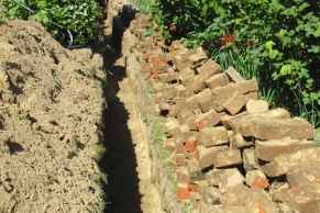 Rohrgraben für eine Regenwasserleitung im Garten